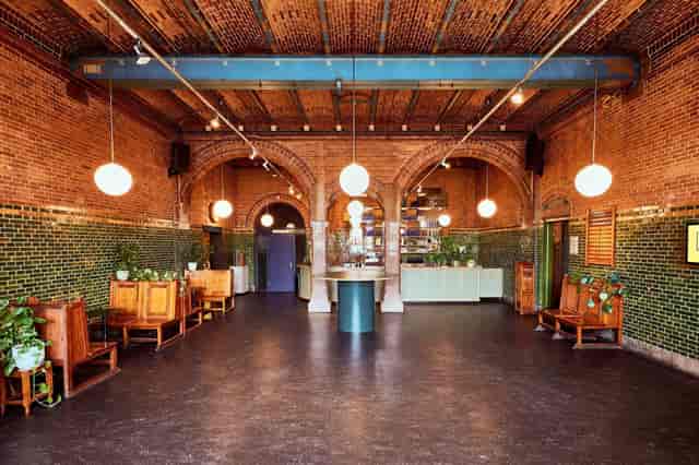 Stylish Lotenzaal event space with exposed brick walls and warm lighting for gatherings.