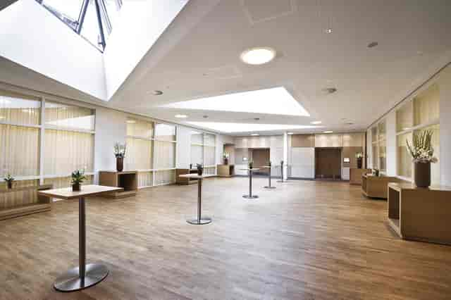 Minimalist ijVENUES foyer with cocktail tables for networking events and corporate receptions.
