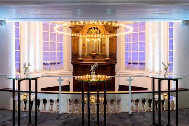 Elegant event space in Koepelkerk Amsterdam with modern glass tables and soft lighting.