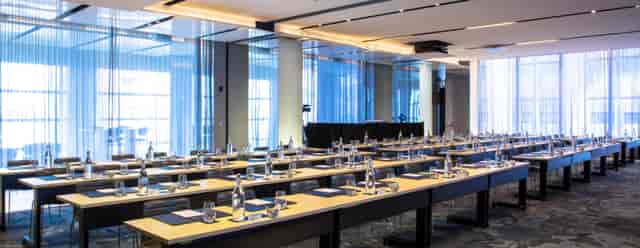 Modern meeting room setup for a corporate event with natural light and interactive layout.