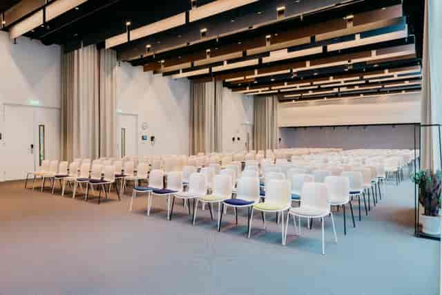 Modern conference space with white chairs at Hotel Casa Amsterdam event center.