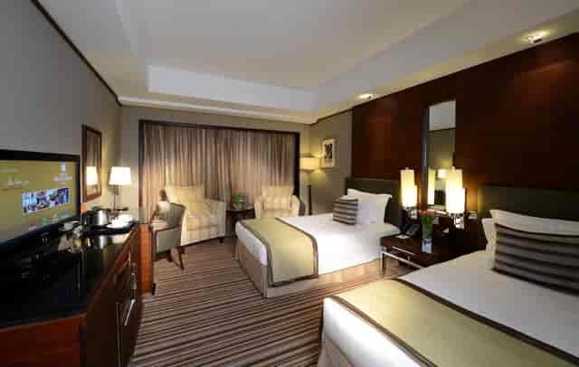 Grand Millennium Dubai twin suite with workspace for corporate business events.