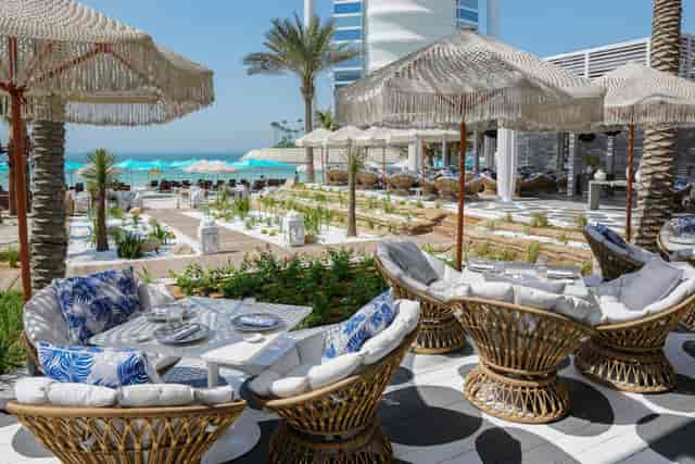 Luxury beachfront restaurant with rattan furniture for corporate events and networking venues.
