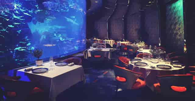 Private dining room at Burj Al Arab with aquarium backdrop for gala dinner or VIP reception.
