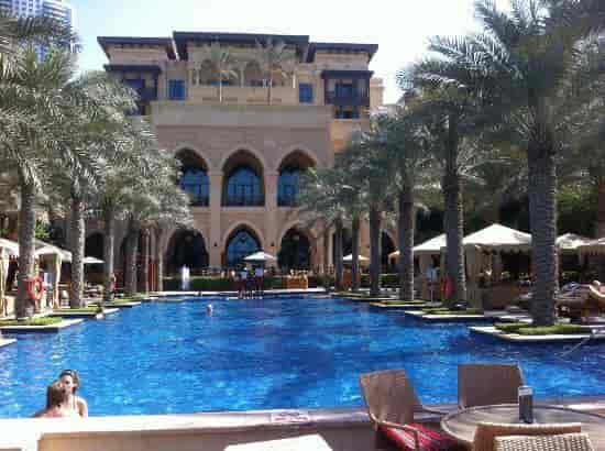 Luxurious pool area with palm trees at Palace Downtown, perfect for elegant events.