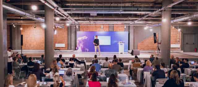 Ω2 Complex Athens Conservatoire: Industrial-chic concrete workshop venue for educational events.