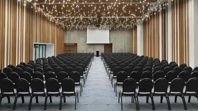 Grand Hall theater-style conference room with wood-slat walls for keynote presentations.
