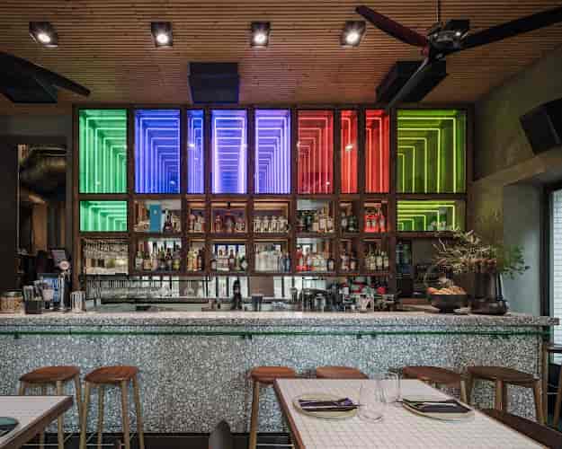 Backlit infinity mirror bar installation for evening networking reception events.