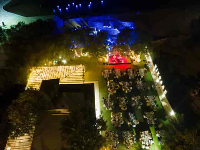 Outdoor gala at Rotundas Reef Athens Riviera with elegant uplighting and stage branding.