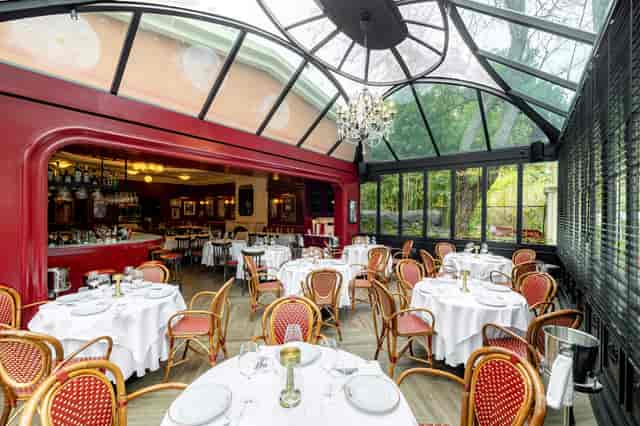 Private dining in glass conservatory at Rick's American Steakhouse for sophisticated events.