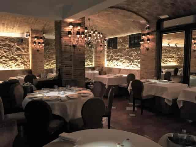 Spondi dining room with stone walls and chandeliers for private events or boutique meetings.