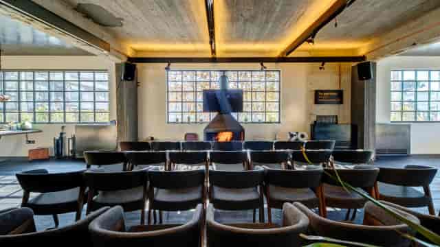 Industrial-chic meeting space with fireplace for professional workshops and boutique presentations.