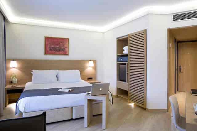 Modern guest room with dedicated workspace at Kalypso Golden Age Hotel for business travel.