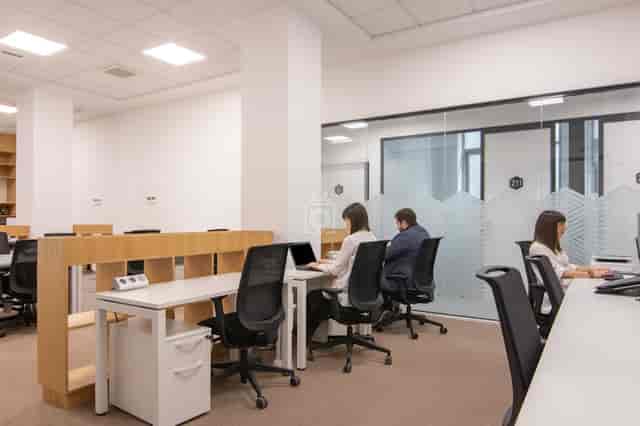 Ergonomic coworking space with glass partitions for productivity and team meetings.