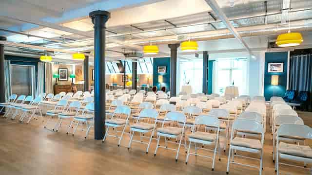 Event space at La Galeria with white chairs, perfect for meetings and presentations.