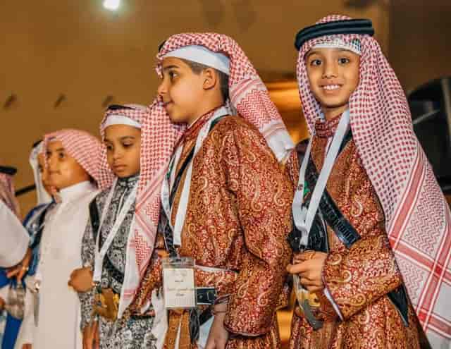 Young people in traditional attire at Ardah performance: cultural event and summit photography.