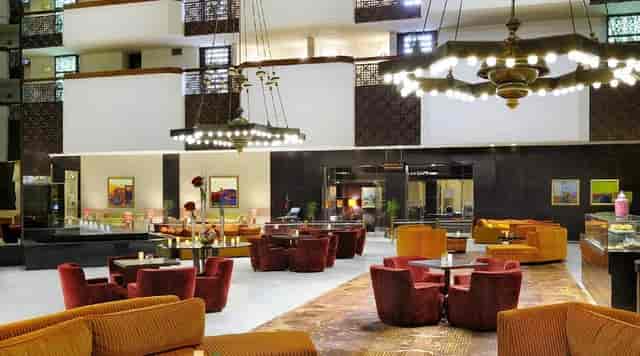 Otium hotel atrium with lounge seating for business networking and event registration.