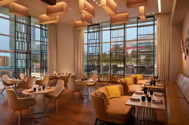 High-end QEUZ restaurant with floor-to-ceiling windows, ideal for corporate events and networking.