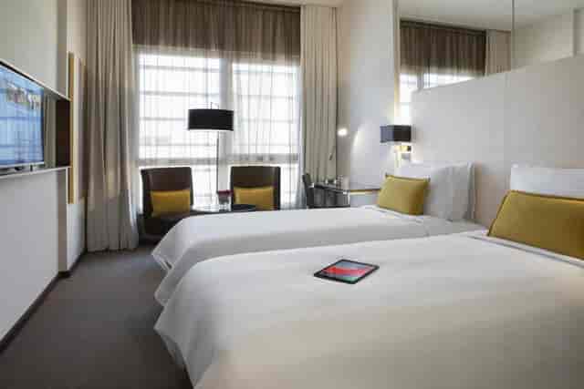 Twin-bedded corporate room at Centro Waha featuring modern workspace for business travel.