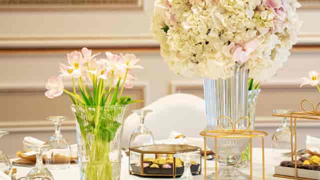 Luxury hotel table setting with tiered floral centerpieces for boutique weddings and gala events.