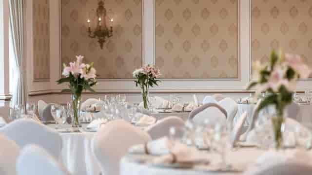 Elite banquet hall with elegant floral centerpieces for formal events and luxury weddings.