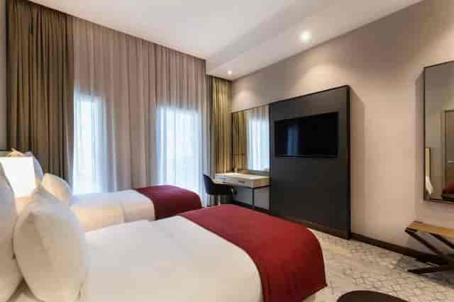 Modern twin guest room at Ramada Riyadh for business conferences and corporate meetings.