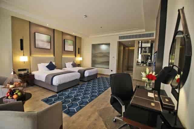 Braira Al Wizarat twin-bed hotel room with workspace for corporate events and business travel.