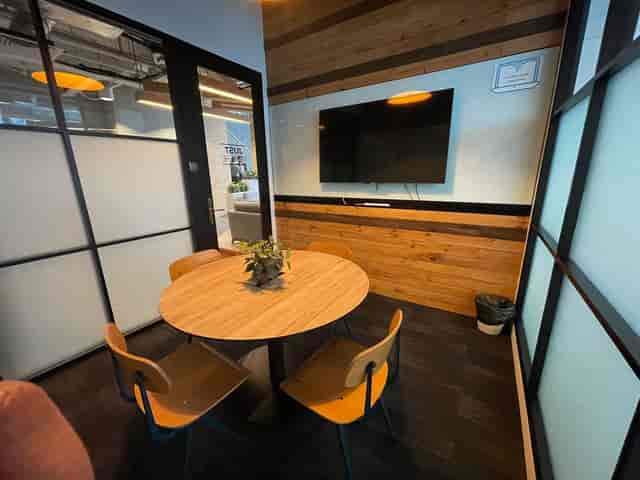 Modern glass huddle room for collaborative breakout sessions and corporate team meetings.