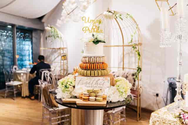 Elegant dessert station with macaron tower and wedding cake for luxury wedding reception venue.