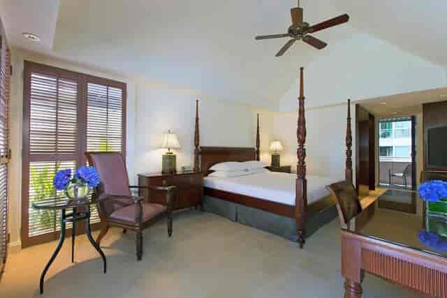 Colonial-style suite with four-poster bed for executive lodging and luxury hotel room blocks.