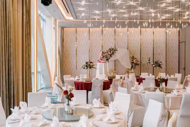 Modern Queen Ballroom wedding venue with chandeliers and burgundy decor for formal receptions.