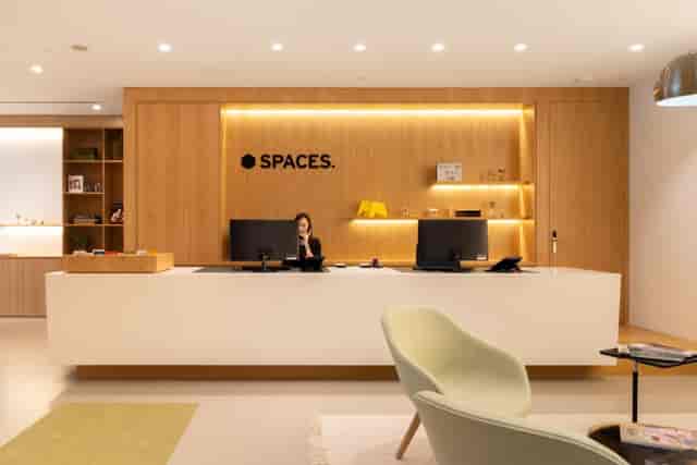 Modern coworking space reception with wood accents for professional meetings and office rentals.