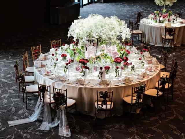 Grand Ballroom wedding gala setup with oversized floral centerpiece and gold chiavari chairs.