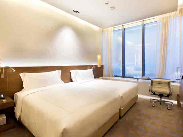 Modern twin guest room at One Farrer Hotel, ideal for corporate travel and business meetings.
