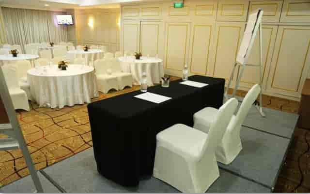 Sapphire meeting room with stage and round tables for corporate conference and plenary session.