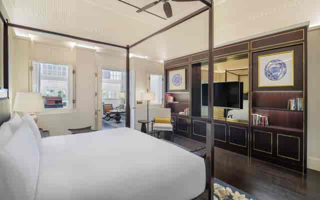 Luxury hotel suite with four-poster bed for VIP speaker accommodations and executive events.