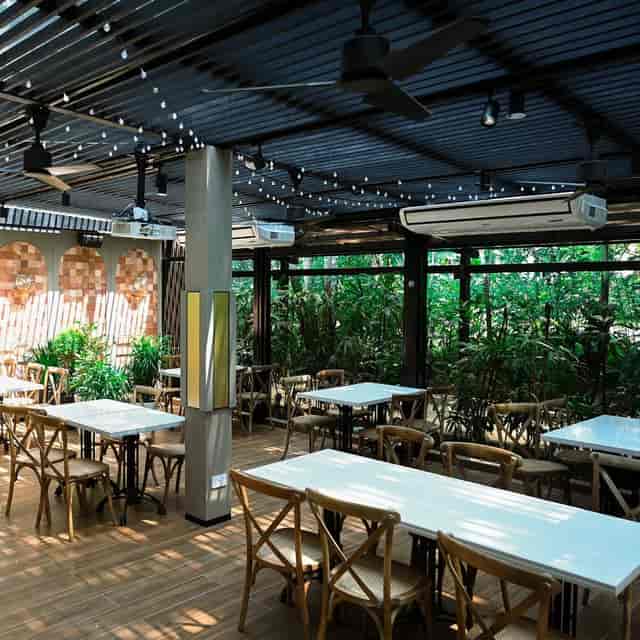 Covered garden restaurant with string lights for networking mixers and corporate breakout events.