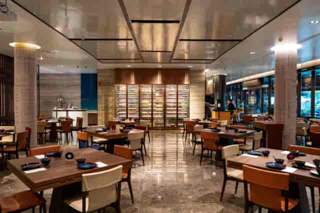 Upscale Yuè private dining room with illuminated wine cellar for corporate events and networking.