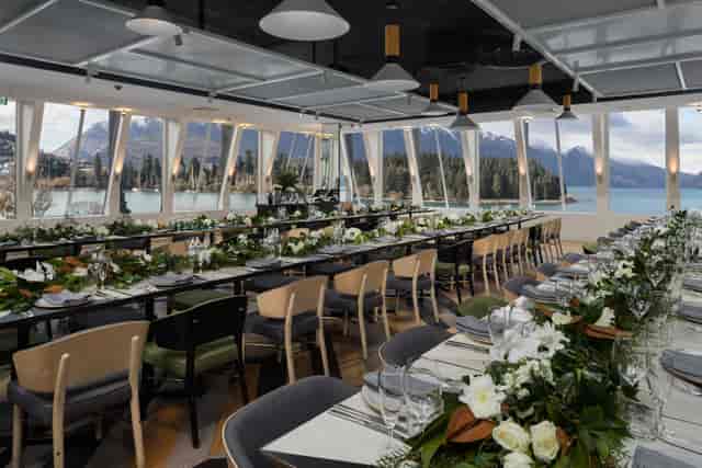 Clancy’s Room banquet setup with lake views, floral runner, ideal for corporate galas or weddings.