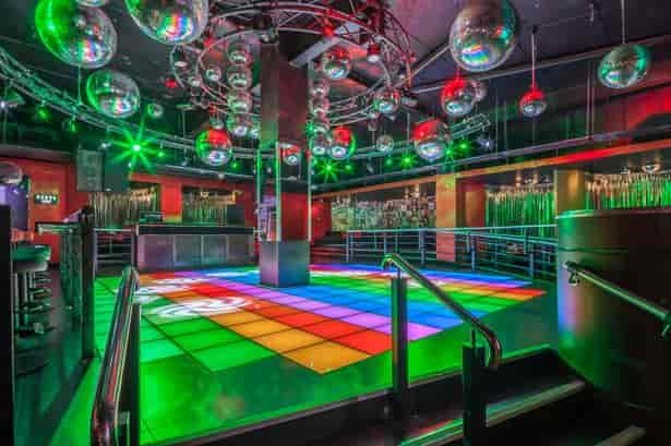 VIP booths with LED dance floor and disco balls at a corporate party or gala event space.