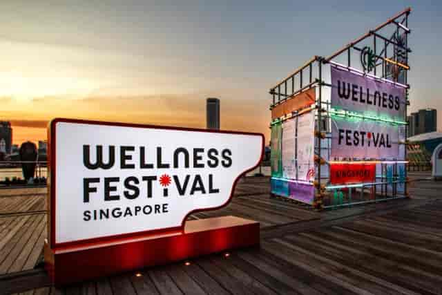 Wellness Frequent Flyer Plus branded scaffolding at an outdoor experiential marketing event.