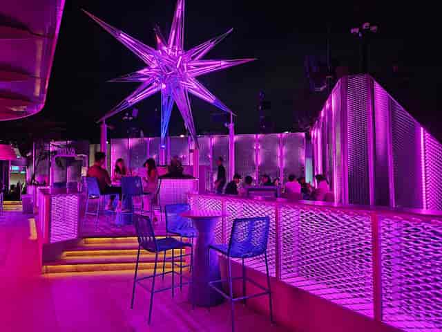 Upscale rooftop networking bar with purple lighting for corporate and evening events.