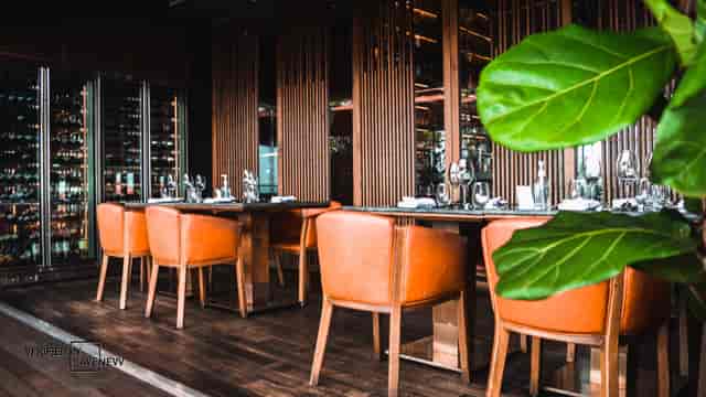 Private dining room at CÉ LA VI Singapore with elegant orange chairs for corporate events.