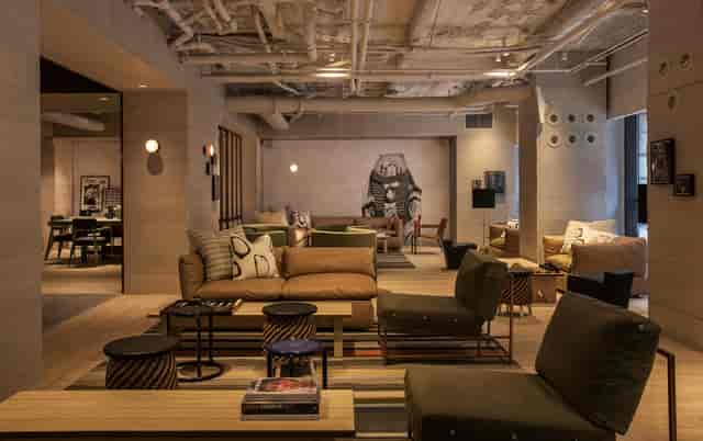 Industrial-chic Moxy Times Square breakout space with modular seating for networking and workshops.