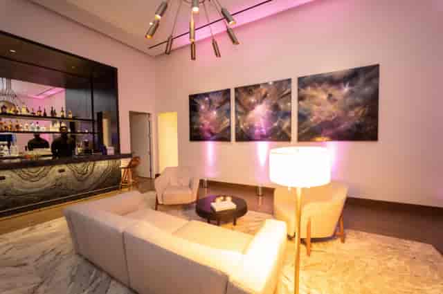Contemporary VIP green room lounge with integrated bar for networking and executive events.