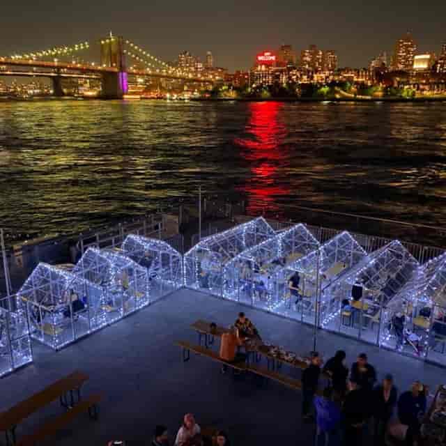Waterfront pop-up dining with illuminated igloos for private events and outdoor corporate functions.