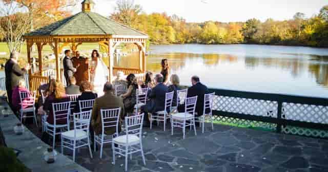 Lakeside gazebo wedding ceremony at The Stone House, waterfront outdoor venue for event planning.