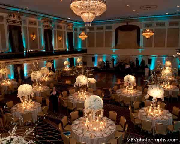 Elegant Roosevelt Hotel ballroom for gala or corporate event with tall floral centerpieces.