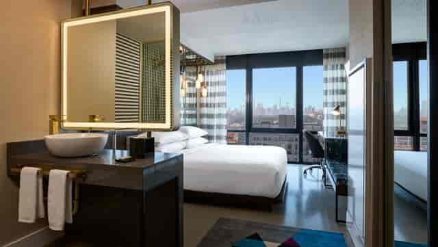 Modern Renaissance Harlem hotel guest room with city views for executive travel and site inspections.