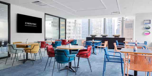 Modern meeting room with round tables and digital display for corporate events and workshops.